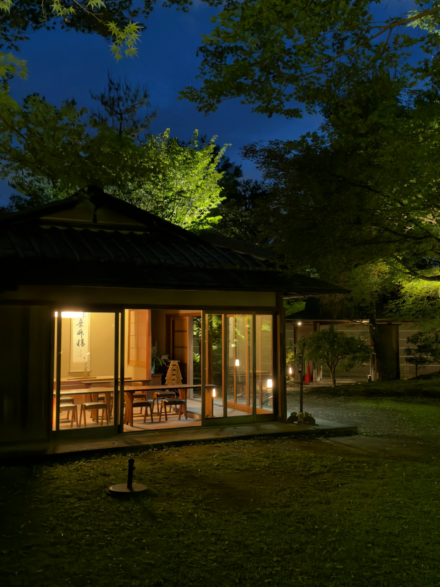 夜に室内の明かりがもれる、庭に面した部屋